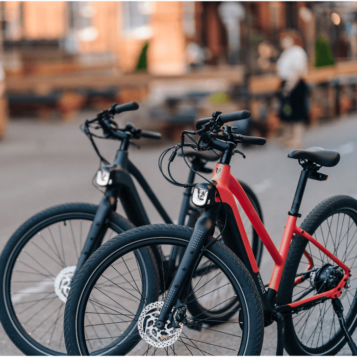 Two Vvolt Alpha II E-Bikes parked in the city. 